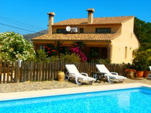 una villa con piscina di fronte a una casa di Finca El Corral a Lliber