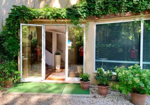 une porte ouverte d'une maison avec des plantes en pot dans l'établissement Hotel Garni Picnic, à Riccione