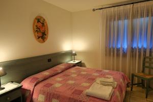 a bedroom with a bed with a red blanket and a window at RosArancio in Bassano del Grappa