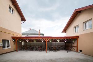 un patio avec des chaises et des tables dans un bâtiment dans l'établissement Casa Burduhos, à Câmpulung Moldovenesc