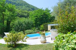 una piscina in un giardino con un vaso di RosArancio a Bassano del Grappa