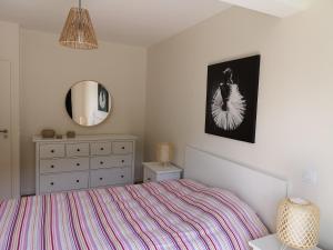 sypialnia z łóżkiem, komodą i lustrem w obiekcie A5 - Résidence La Montille w mieście Mont-Dore