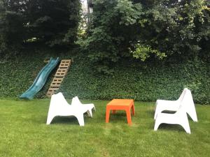 a group of chairs in the grass with a slide at La Grande Maraudeuse in Theux