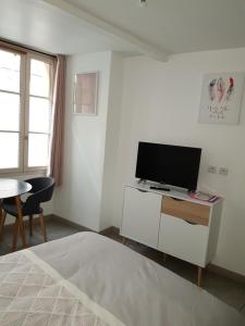 a bedroom with a tv and a table and a bed at Charmant studio au coeur de St Leu hyper centre in Amiens