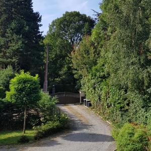 a path in a garden with trees and a fence at Studio Haras in Wavre