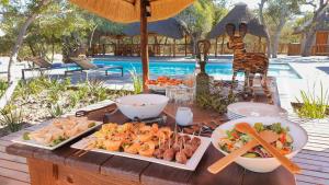 un tavolo con piatti di cibo sopra di Vuyani River Lodge a Hoedspruit