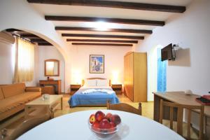 a living room with a bed and a bowl of fruit on a table at Pension Ioanna in Adamantas