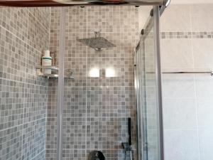 bagno con doccia e porta in vetro di Cosy Apartment a Grado