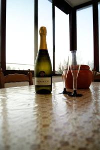 una bottiglia di vino seduta su un tavolo con due bicchieri di La Veranda sul mare a Monopoli
