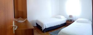 a small bedroom with two beds and a mirror at Augustinovi Dvori in Škrip