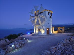 a building with a windmill at night at Anemomilos in Koríthion