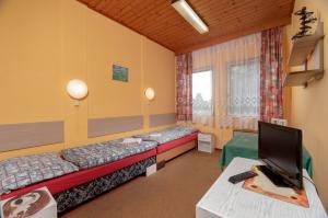 Habitación con 2 camas y TV. en Ubytovna Z-SPORT en Nové Město nad Metují