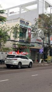 Un todoterreno blanco estacionado al lado de una calle de la ciudad en Minh Minh Hotel, en Quy Nhon