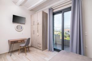 een slaapkamer met een bureau en een raam bij EL.MA.RA. Luxury Villas in Kókkinos Pírgos