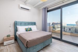 een slaapkamer met een bed en een groot raam bij EL.MA.RA. Luxury Villas in Kókkinos Pírgos +54 foto's
