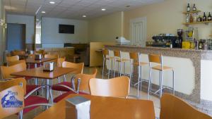 a restaurant with tables and chairs and a counter at Pension Playa Mar Cachadiñas in Balea