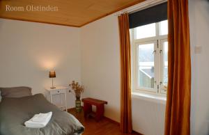 een slaapkamer met een bed en een raam bij The Manor House in Hamnøy in Reine