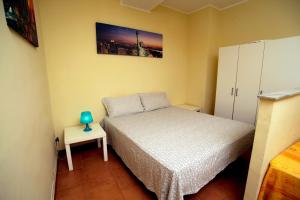 カターニアにあるCatania Apartment Liotroの小さなベッドルーム(ベッド1台、サイドテーブル付)