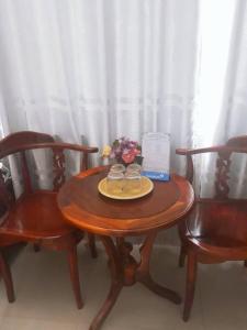 a wooden table with two chairs and a laptop on it at Minh Minh Hotel in Quy Nhon