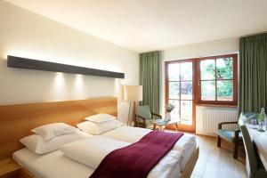 オプシュタイクにあるDer Stern - Nachhaltiges Wirtshaus und Landhotel seit 1509のベッド、デスク、窓が備わるホテルルームです。