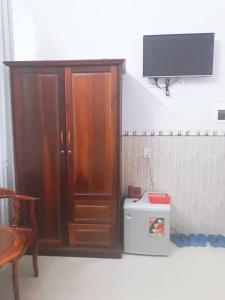 a wooden cabinet in a room with a tv at Minh Minh Hotel in Quy Nhon