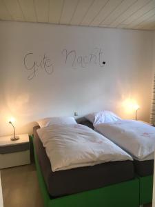 ein Schlafzimmer mit 2 Betten und ein Schild an der Wand in der Unterkunft Gemütliches Appartement nähe Zentrum mit Küche in Haßfurt