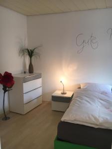 ein Schlafzimmer mit einem Bett und eine Kommode mit einer Pflanze in der Unterkunft Gemütliches Appartement nähe Zentrum mit Küche in Haßfurt