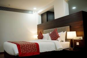 a bedroom with a large bed with red and white pillows at The Terrace by Ladder Mgd by Citrine in Trivandrum