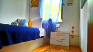 sypialnia z łóżkiem z niebieską pościelą i oknem w obiekcie Apartments Zunic w Trogirze