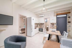 een keuken en eetkamer met een tafel en stoelen bij EL.MA.RA. Luxury Villas in Kókkinos Pírgos