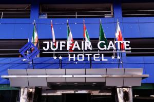 un letrero para un hotel de la puerta jucah con banderas en Juffair Gate Hotel en Manama