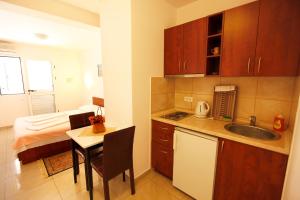 a small kitchen with a table and a bed at Apartments Baron in Sveti Stefan