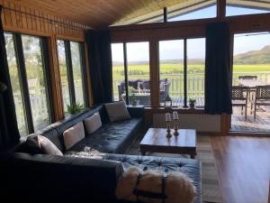 a living room with a couch and a table at Jaðar Holiday House in Tungufell