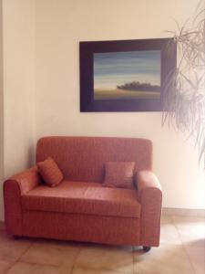 een bruine bank in een woonkamer met een schilderij bij AllogGio' in Calice Ligure