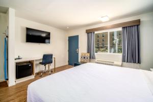 1 dormitorio con 1 cama blanca grande y escritorio en Trend Hotel at LAX Airport en Inglewood