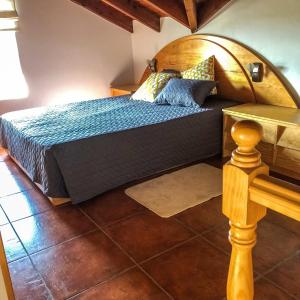 a bedroom with a bed with a wooden headboard at eSense - Formosinha in Madalena