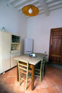 Una cocina con una mesa con sillas y un refrigerador. en Il Balconcino sulle Terme, en San Giuliano Terme