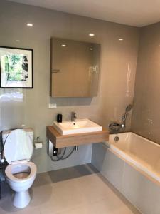 a bathroom with a toilet and a sink and a tub at Live Your Dream Khaoyai in Phayayen