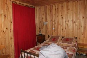 a bedroom with a bed and a red curtain at Rdc Chalet in Pra-Loup