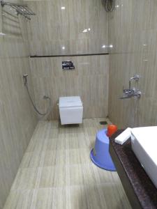 a bathroom with a shower and a toilet and a sink at saravanaa residency in Madurai
