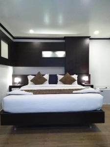 a bedroom with a large bed with a black headboard at saravanaa residency in Madurai