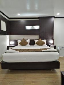 a large bedroom with a large bed with white sheets at saravanaa residency in Madurai