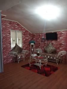 a living room with a brick wall with a tv at Pondok Oma in Lasikin