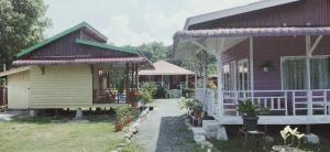 ein Haus mit einer Veranda und einem Gebäude mit Topfpflanzen in der Unterkunft Pondok Oma in Lasikin