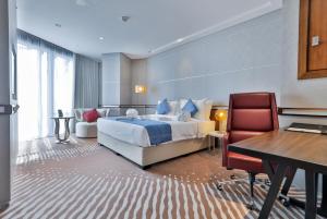 ドーハにあるVIP Hotel Doha Qatarのベッドとデスクが備わるホテルルームです。
