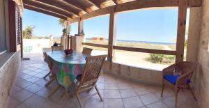 a table and chairs on a porch with a view of the beach at Home Music & Love in Favignana