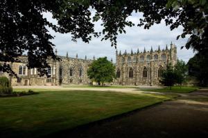 a large stone building with a green lawn in front of it at Cosy two bedroom apartment in Bishop Auckland