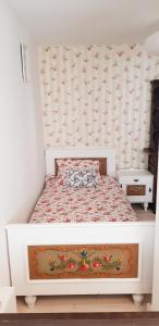 a small bedroom with a bed with a flowery wallpaper at Ferienwohnung Rosenheim in Wagenham