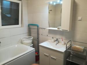 uma casa de banho com um lavatório e um espelho em Apartments Juhart em Nin