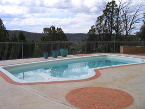 ein kleiner Pool in einem Garten mit einem Zaun in der Unterkunft Cooma High Country Motel in Cooma